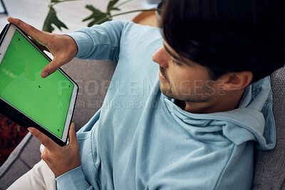 Buy stock photo Tablet, green screen and a man playing games on a sofa in the living room of his home from above. Technology, gaming and young gamer using a display or screen with tracking markers for entertainment