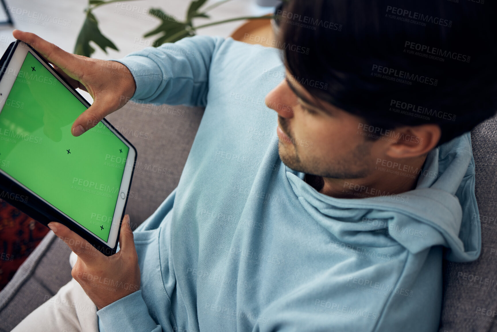 Buy stock photo Tablet, green screen and a man playing games on a sofa in the living room of his home from above. Technology, gaming and young gamer using a display or screen with tracking markers for entertainment