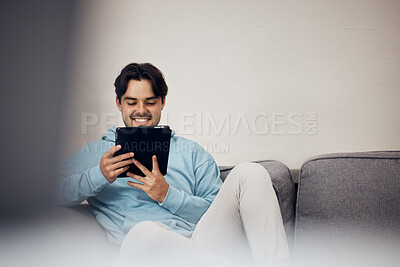 Buy stock photo Happy man, tablet and relax on sofa for social media, communication or entertainment in living room at home. Male person, smile and lying on lounge couch with technology for online streaming at house