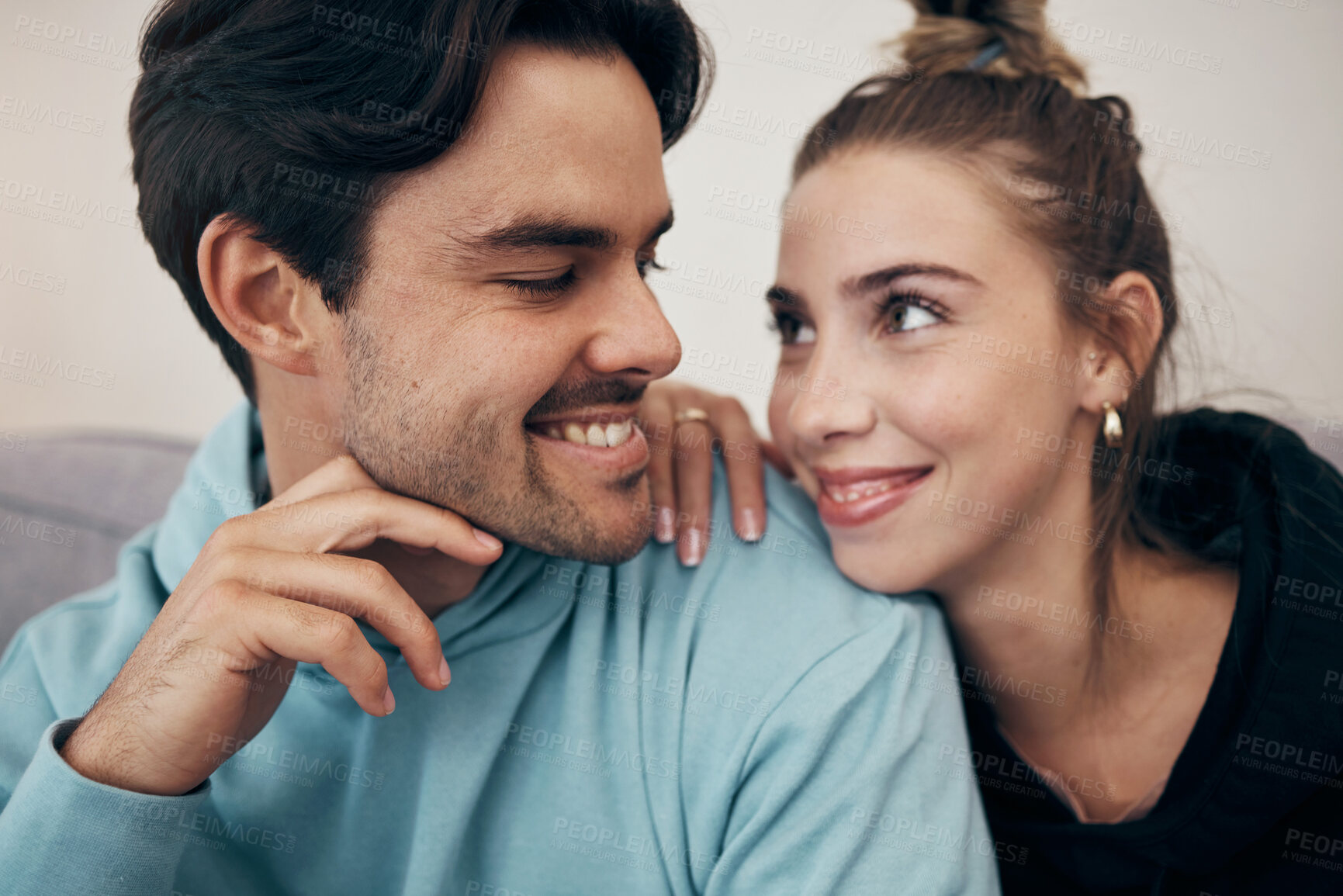 Buy stock photo Happy, bond and couple relax on a sofa with care, hug and support at home together. Love, face and young people in a living room smile, chilling and enjoy weekend, relationship or day off in a house