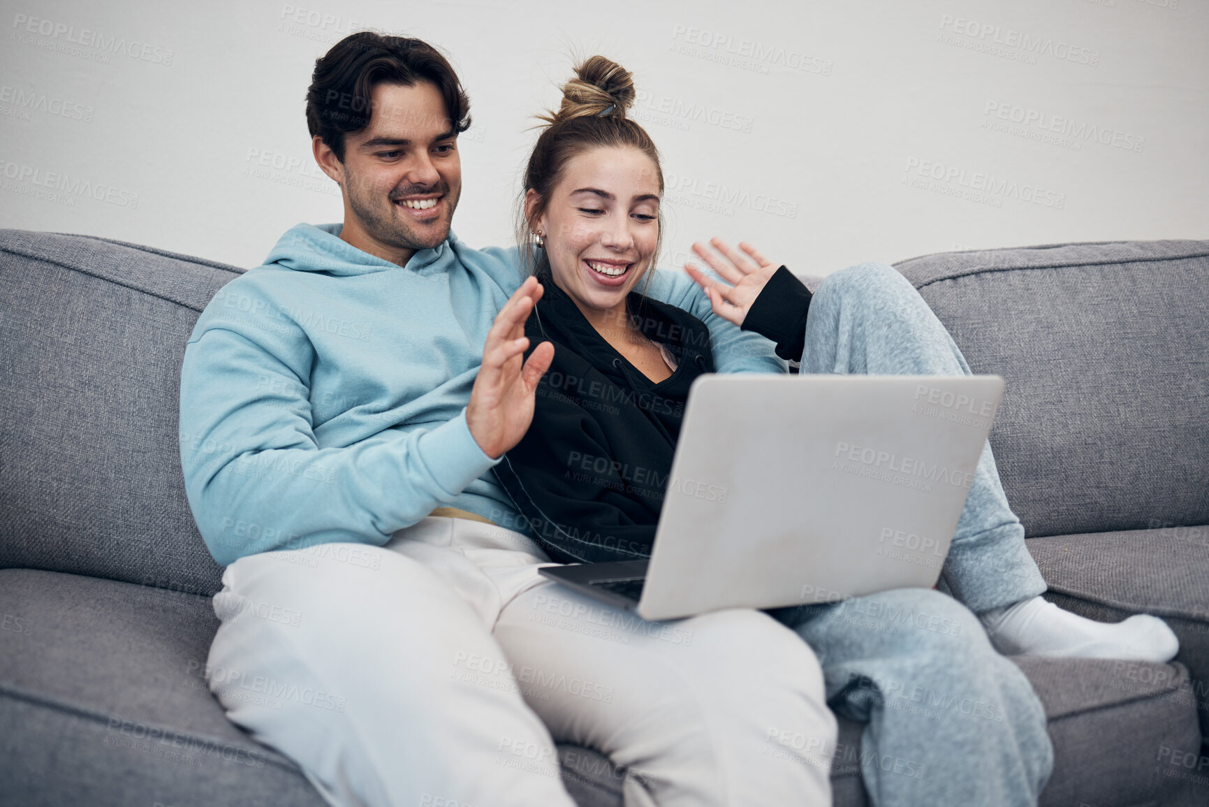 Buy stock photo Couple, video call and wave on laptop in living room with communication for family. Young man, woman and together in happiness, embrace or love in relationship on sofa with technology, web or app