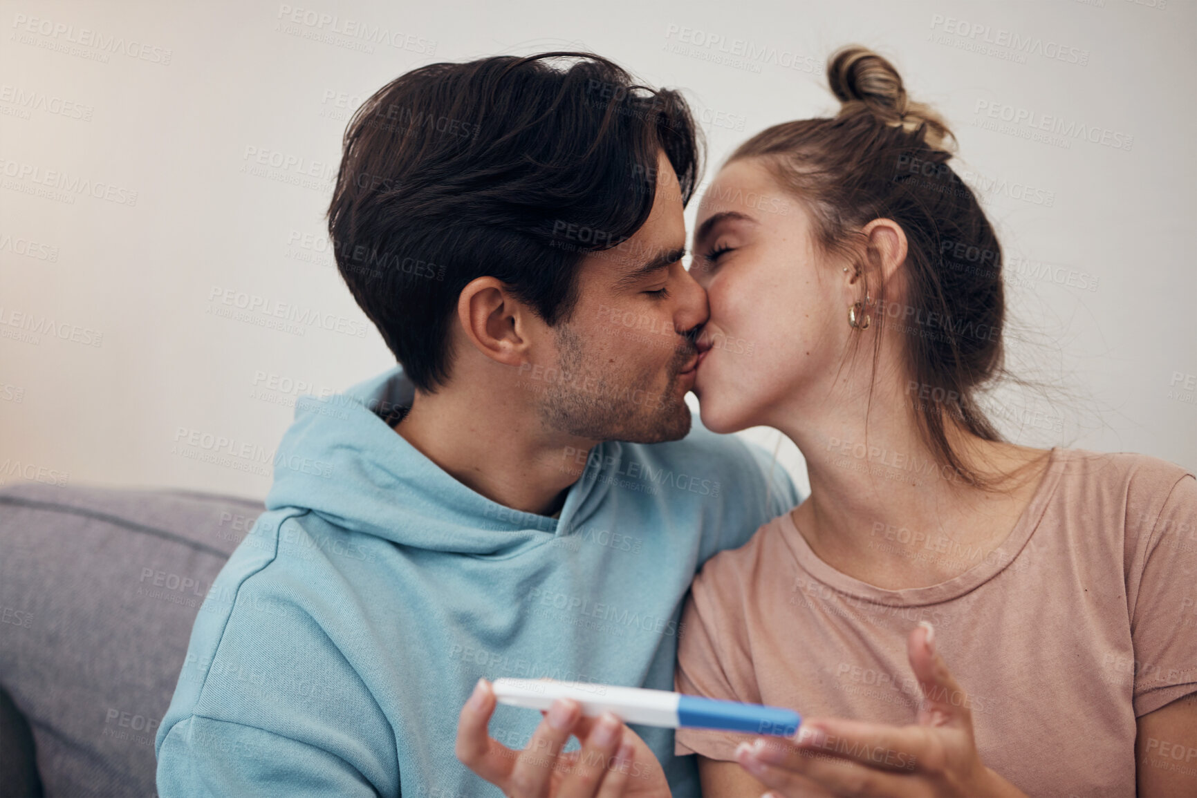 Buy stock photo Pregnancy, test and couple kiss in home living room for good news or positive results. Romance, man and pregnant woman with stick on sofa together happy at success, future maternity or ivf fertility