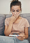 Pregnancy test, shock and sad woman on sofa in home, reading bad news and check negative exam results. Stick, surprise and pregnant mother depressed in living room for maternity, stress and anxiety