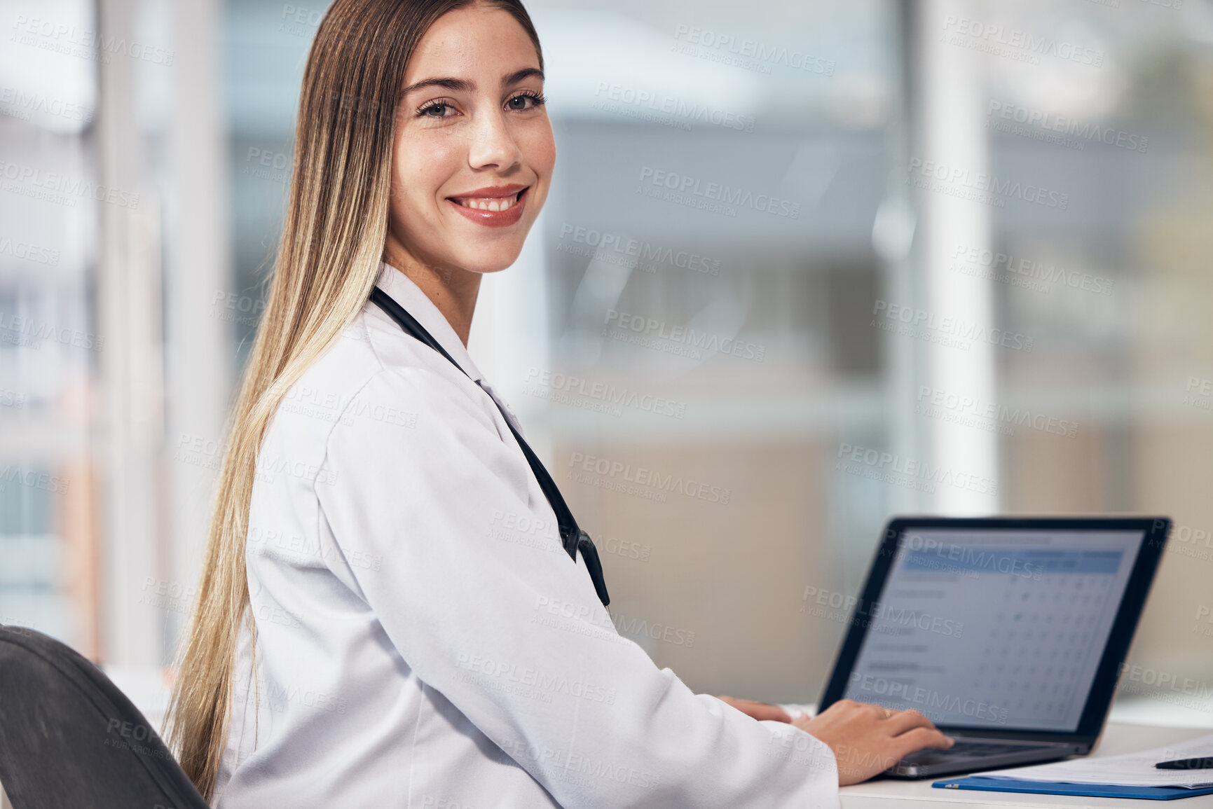 Buy stock photo Portrait, doctor and laptop with a woman typing in a hospital for healthcare, consulting or trust. Medical, smile and a happy young medicine professional working at a desk in a clinic for cardiology
