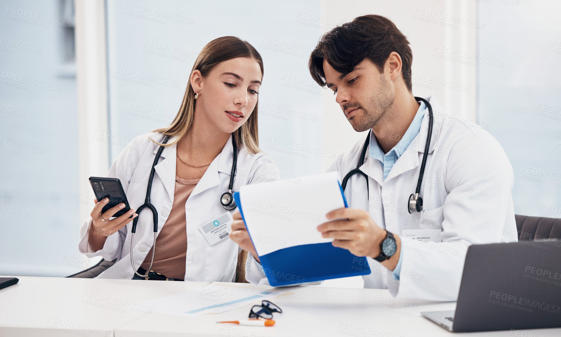 Buy stock photo Doctors, healthcare and working together with clipboard for planning, research and medical schedule at desk in hospital. Medicine, man and woman with collaboration, teamwork or brainstorming results