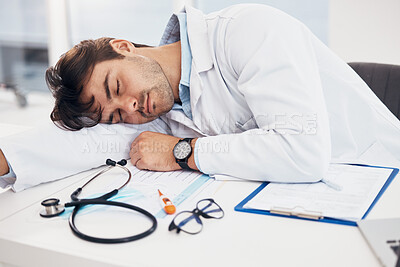 Buy stock photo Healthcare, tired and a doctor man sleeping at his desk in the hospital with fatigue or exhaustion. Medical, burnout and an overworked young medicine professional asleep in his office at the clinic