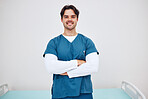 Portrait, doctor and arms crossed for smile in space for health, treatment or wellness. Happy man, physiotherapist and scrubs for career in medicine by emergency care, cardiology or rehabilitation


