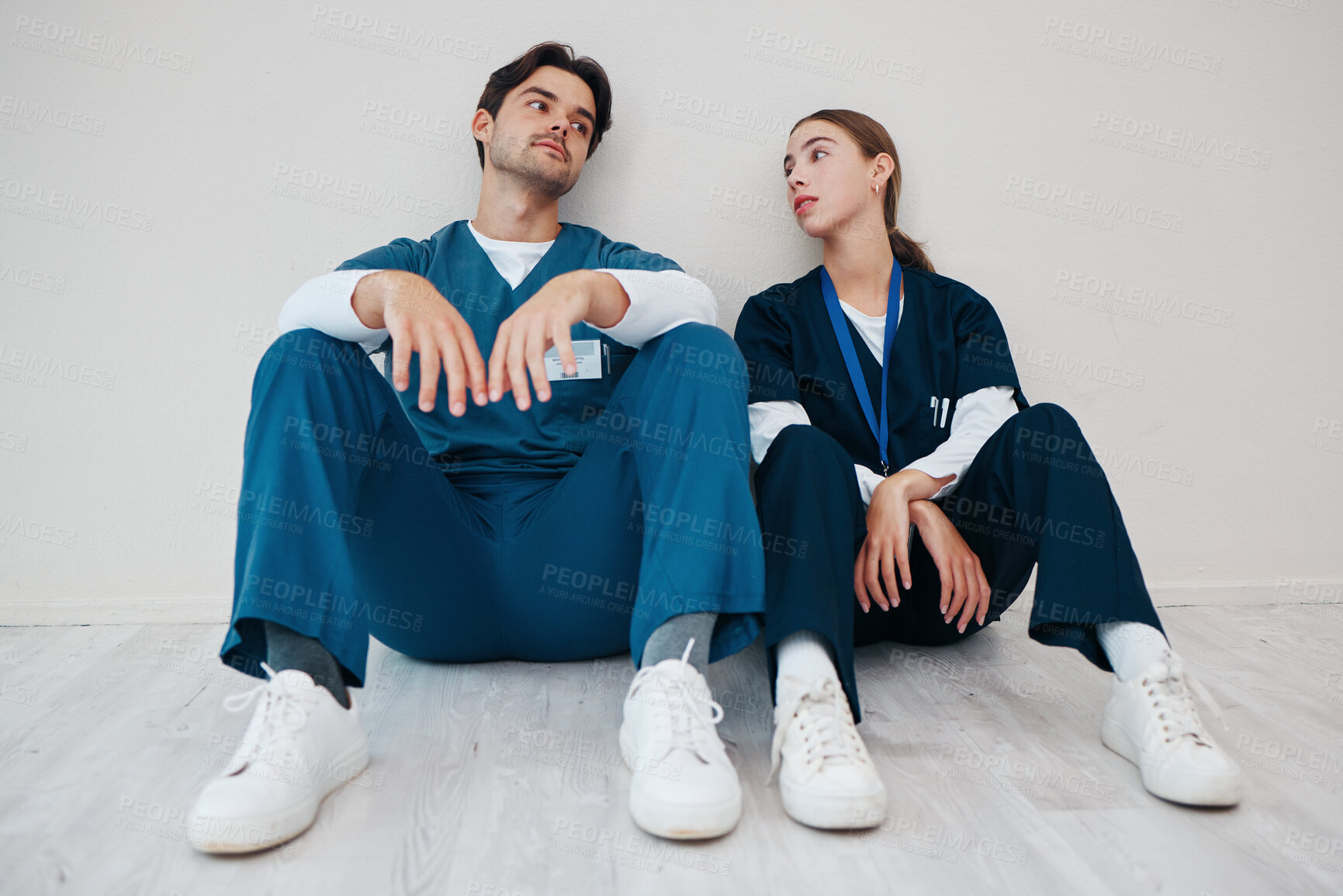 Buy stock photo Nurses, serious couple and relax in hospital, talking and communication. Medical workers, man and woman on break, conversation and healthcare team bonding, support and connection for love in clinic