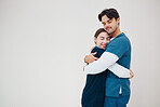 Doctor, colleagues and hug smile at healthcare clinic, support or work stress. Medical professionals, friends or helping comfort in scrubs or wall background, mockup space or happy trust at hospital