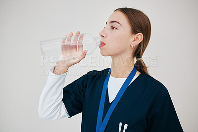 Buy stock photo Nurse, woman drinking water in bottle and health, wellness or body nutrition in studio isolated on white background in hospital. Medical professional, hydration and liquid of thirsty surgeon on break