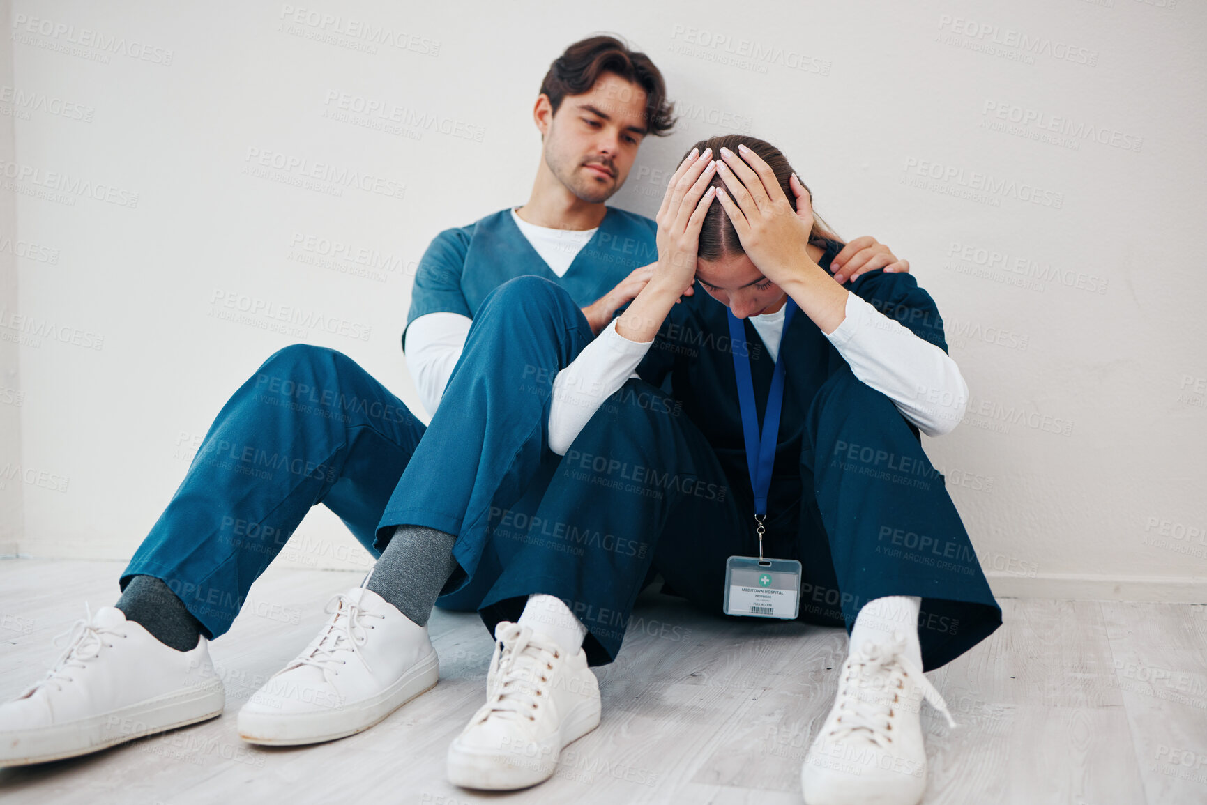 Buy stock photo Crying doctors, clinic floor and woman with man, support or empathy for regret, death or fail in surgery. Medic, partnership and burnout with depression, mistake or anxiety for healthcare in hospital