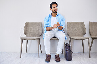 Buy stock photo Waiting room, recruitment and man in an office for interview in job search for appointment. Hiring, career and Indian male person sitting on chair for meeting with human resources in modern workplace