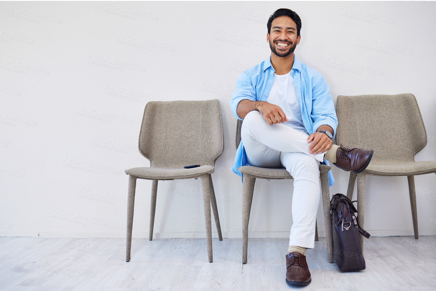 Buy stock photo Smile, waiting and man in the office for recruitment meeting with human resources for hiring. Confidence, professional and person sitting on a chair for job interview in hallway in modern workplace.