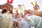 Hands, group and champagne toast at Christmas, office party and celebration drink with cheers with friends. Excited people, xmas and glass for alcohol, sparkling wine and happy at event for holiday