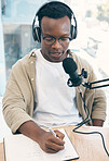 Radio, podcast and black man in office writing notes for advice, questions or feedback while live streaming. Speech, presenter and African male with broadcast announcement, news or hosting talk show