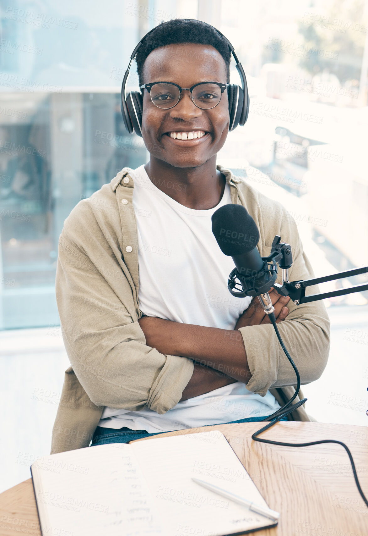 Buy stock photo Portrait, radio and black man with a notebook, microphone and arms crossed with content creator, live stream and news. Face, African person or podcast presenter with tech, share information and media