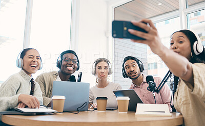 Buy stock photo Podcast, funny face and group selfie of friends together, live streaming or people recording broadcast on headphones or mic in studio. Radio host team laughing, take photo at table and social media