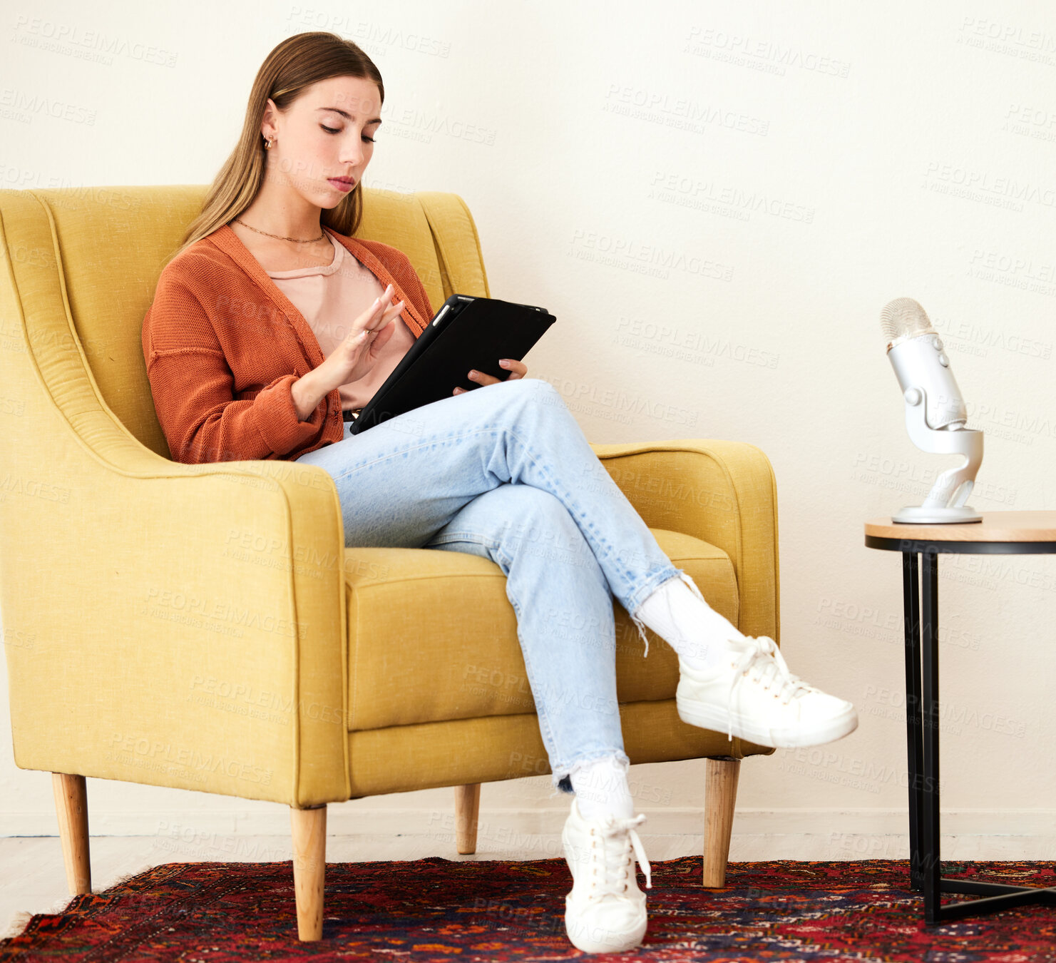 Buy stock photo Tablet, microphone and woman on a chair for podcast doing research on internet or social media. Radio, serious and young female person scroll on mobile app with digital technology in recording space.