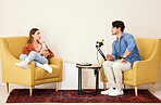 Man, woman and mic for podcast, speaking or question in conversation, interview and lounge chair. Talk show, microphone and people together for broadcast, live streaming and tablet for social network