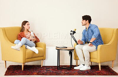 Buy stock photo Man, woman and mic for podcast, speaking or question in conversation, interview and lounge chair. Talk show, microphone and people together for broadcast, live streaming and tablet for social network
