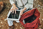 Hands, hiking and a person with a tablet in nature for gps location, search or a map for travel. Above, internet and a tourist typing on technology for connection while trekking in the forest