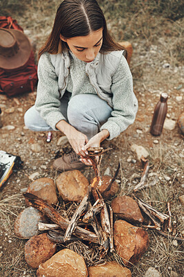 Buy stock photo Wood, nature and woman with fire on a camp on a mountain for adventure, weekend trip or vacation. Stone, sticks and young female person making a flame or spark in outdoor woods or forest for holiday.