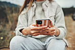 Nature, hands and closeup of woman on a phone networking on social media, mobile app or the internet. Technology, mountain and female person typing a text message on cellphone in the countryside.