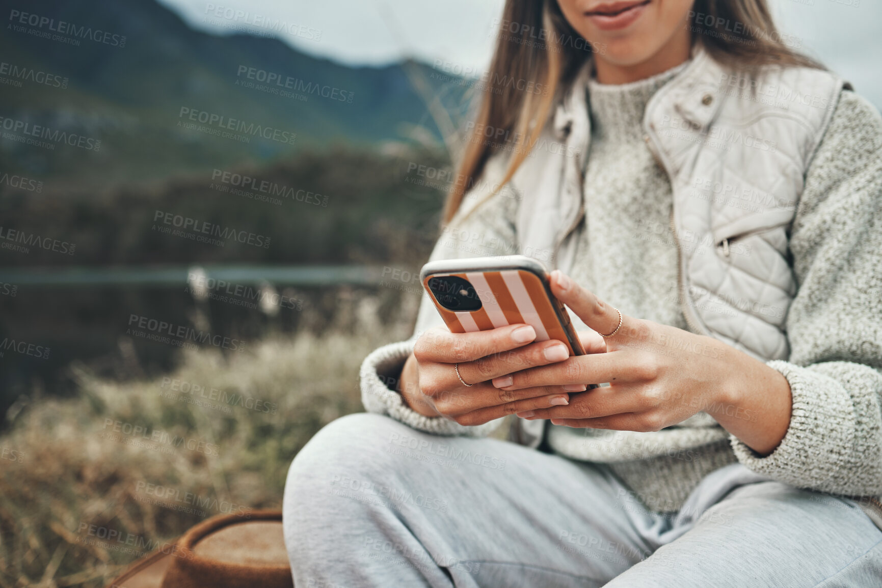 Buy stock photo Mountain, hands and closeup of woman on a phone networking on social media, mobile app or the internet. Technology, nature and female person typing a text message on cellphone in the countryside.