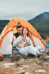 Couple, camping and relax with phone in tent for reading, social media or communication in nature. Happy, people and together in mountain, forest or woods with cellphone, contact or online connection