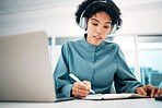 Headphones, laptop and woman writing notes in the office doing research for creative project. Notebook, technology and professional female designer working, planning and listen to music in workplace.