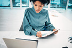 Headphones, technology and woman writing notes in the office doing research for creative project. Notebook, laptop and professional female designer working, planning and listen to music in workplace.