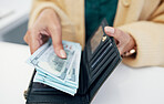 Person, hands and wallet with money for payment investment or savings on counter at checkout. Closeup of employee with cash, bills or paper notes for profit, salary or finance in purchase or shopping