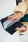 Person, hands and wallet with money for investment, savings or payment on counter at checkout. Top view or closeup of female person with cash, bills or paper notes for finance, purchase or shopping