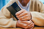 Hands, bible and prayer at desk, religion and Christian worship in home at table. Closeup, holy book and woman in meditation for God, Jesus and Christ for faith in spiritual gospel, praise or hope