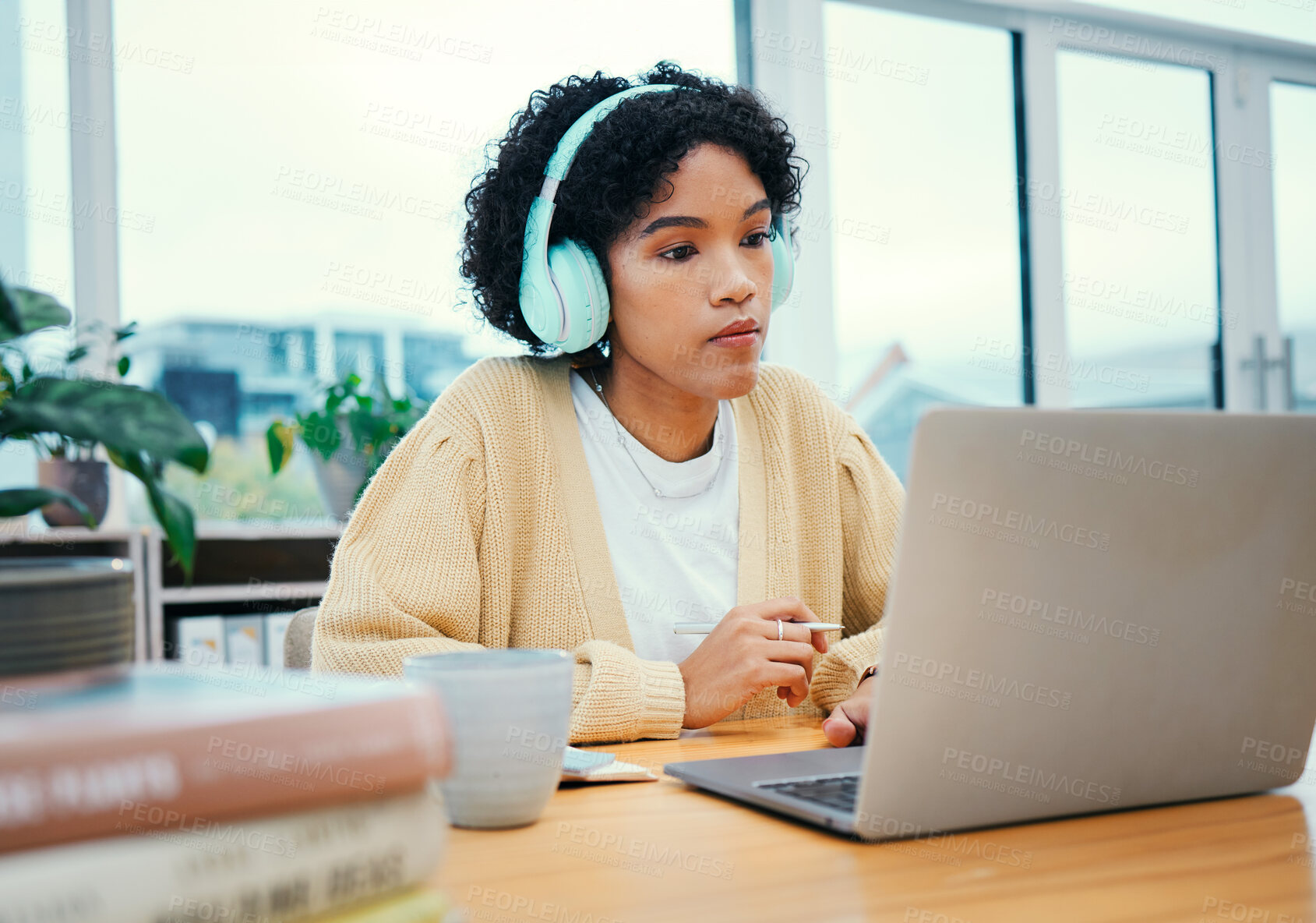 Buy stock photo Serious, headphones and business woman on laptop working in creative startup office. Radio music, computer and professional designer planning at desk, listen to audio podcast online or reading email