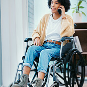 Phone call, talking and woman in a wheelchair in home with ...
