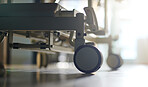 Hospital, bed and wheels of stretcher on floor, ground or interior of empty clinic with equipment. Healthcare, transport and closeup of medical wheeling chair or gurney in medical furniture and room