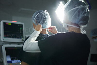 Buy stock photo Getting ready, healthcare and doctors in a surgery theater for medical procedure or treatment. Help, clothing and surgeons with hair nets at a hospital for a clean operation or teamwork in medicine