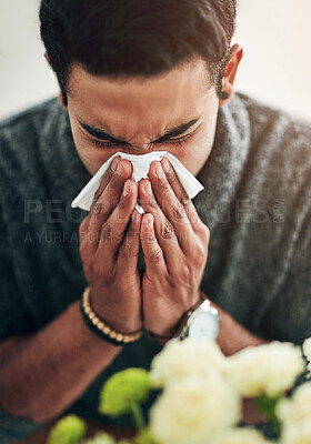Buy stock photo Face, hand and blowing nose with a man using a tissue in his home for relief from allergy symptoms. Sick, cold or flu disease and a young person ill with a virus due to bacteria, pollen or hay fever
