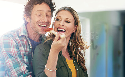 Buy stock photo Love, spoon and taste with a couple cooking in the kitchen of their home together for health, diet or nutrition. Smile, food or sauce with a happy mature man and woman in their house to test a recipe