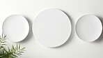 Three white empty round plates on wall. Copy space concept.