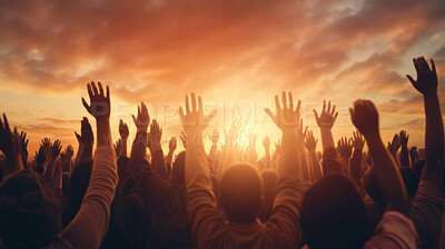 Hands silhouettes of a crowd raised up to worship God against a sunset sky