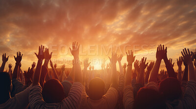 Hands silhouettes of a crowd raised up to worship God against a sunset sky