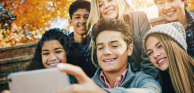 Buy stock photo Smile, friends and a selfie in nature for bonding, fun and video call in autumn. Happy, together and diversity of kids taking a photo on technology in a park for social media or live streaming