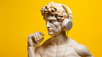 Sculpture or statue of David wearing headphones on yellow background