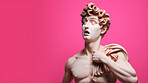 Sculpture or statue of David with shocked or surprised expression on pink background