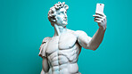 Sculpture or statue of David taking a selfie on a cellphone against a blue background