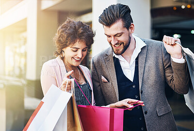 Buy stock photo Shot of a woman showing her boyfriend what she bought while out shopping
