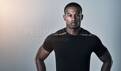 Buy stock photo Studio portrait of an athletic young man standing with his hands on his hips