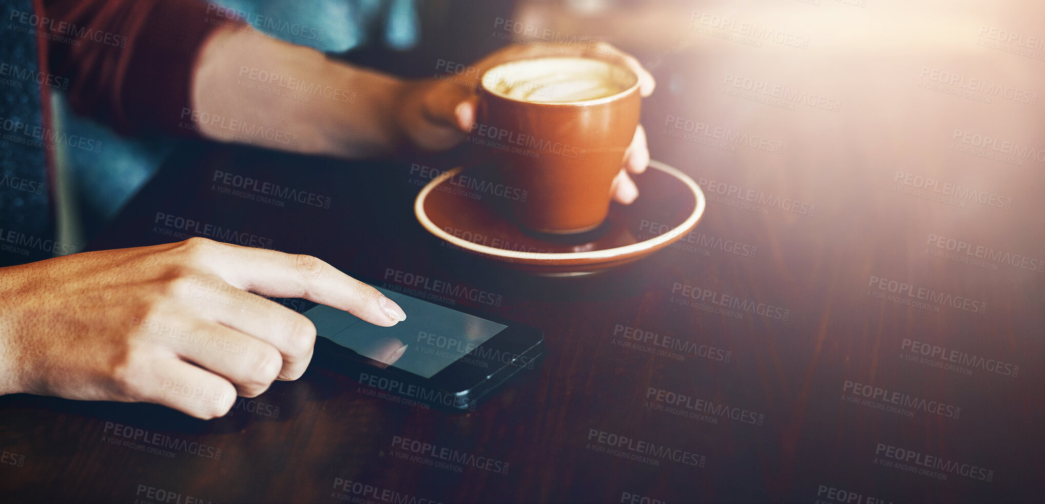 Buy stock photo Coffee shop, phone and hands of person in restaurant for internet, social media and relax with drink. Cafeteria, lens flare and customer on smartphone with caffeine beverage, cappuccino and latte